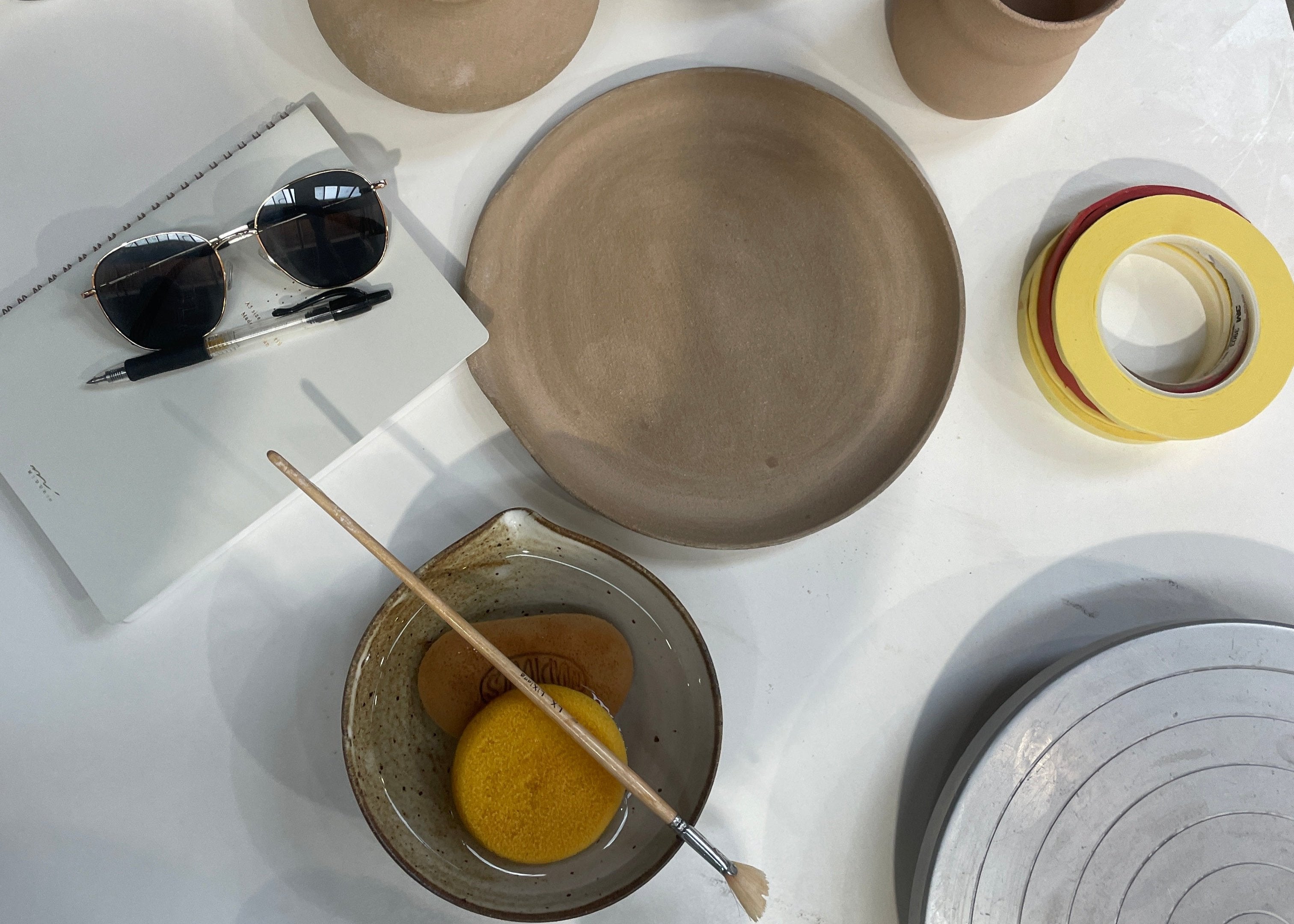 Ceramic bisqueware being cleaned and prepared for firing.